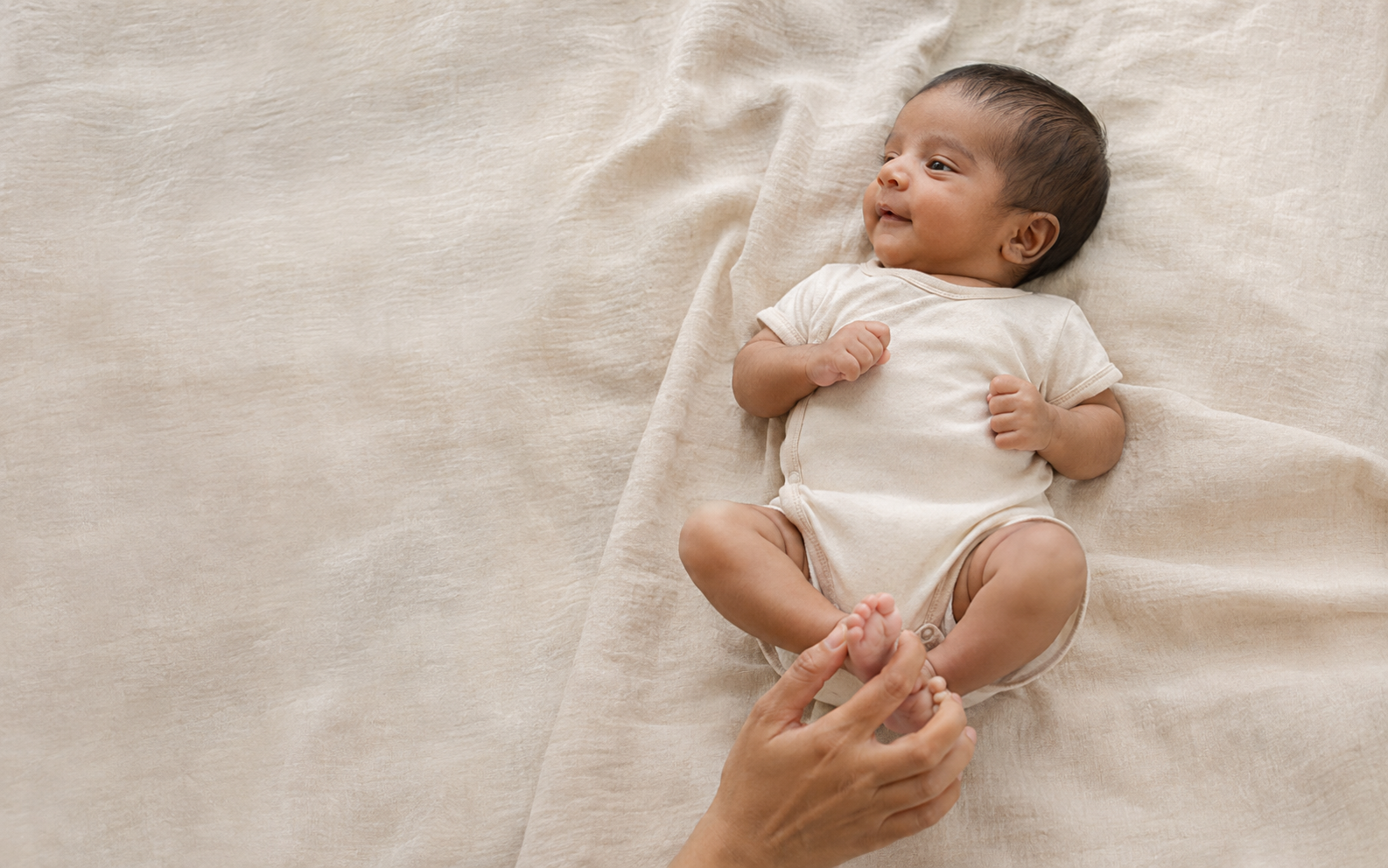 Newborn resting on natural fabric